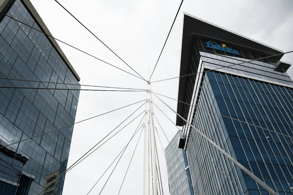 Glass office towers and a cable-stayed bridge pylon viewed from below